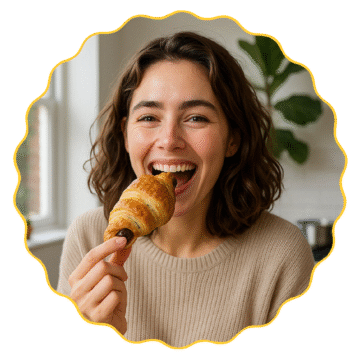 Smiling woman enjoying a chocolate croissant by the window in a cozy morning setting
