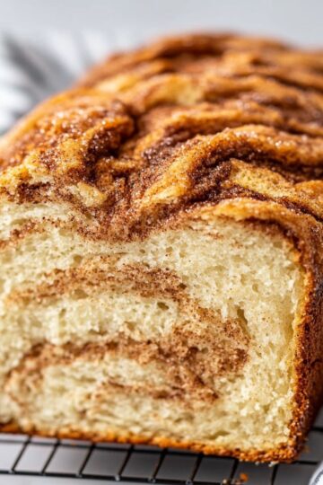 Close-up of Amish cinnamon bread loaf with cinnamon swirls and golden crust