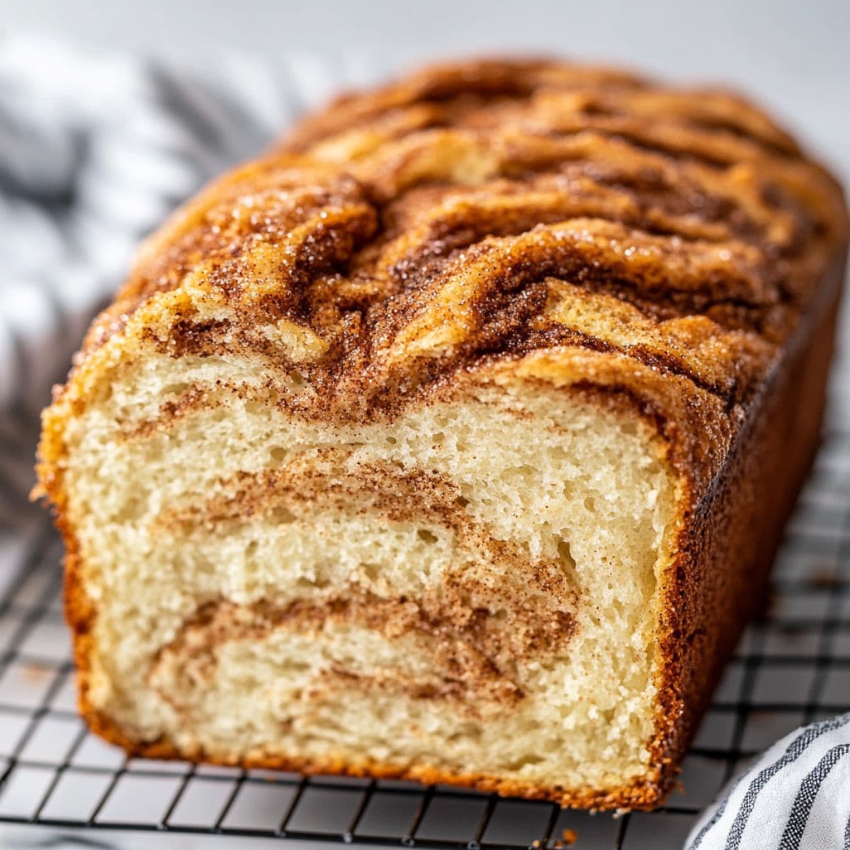 Close-up of Amish cinnamon bread loaf with cinnamon swirls and golden crust