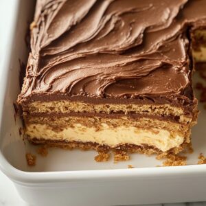 Close-up of sliced chocolate eclair cake with visible layers in a white dish.