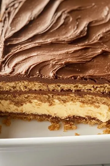 Close-up of sliced chocolate eclair cake with visible layers in a white dish.