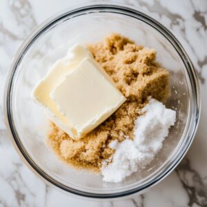 Glass bowl with butter, white sugar, and brown sugar before creaming for muffin batter.