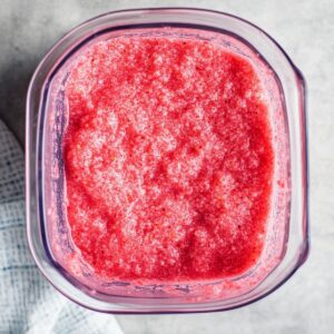 Freshly blended berry slush mixture in a blender before straining