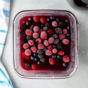 Frozen berries and wine inside a blender before mixing