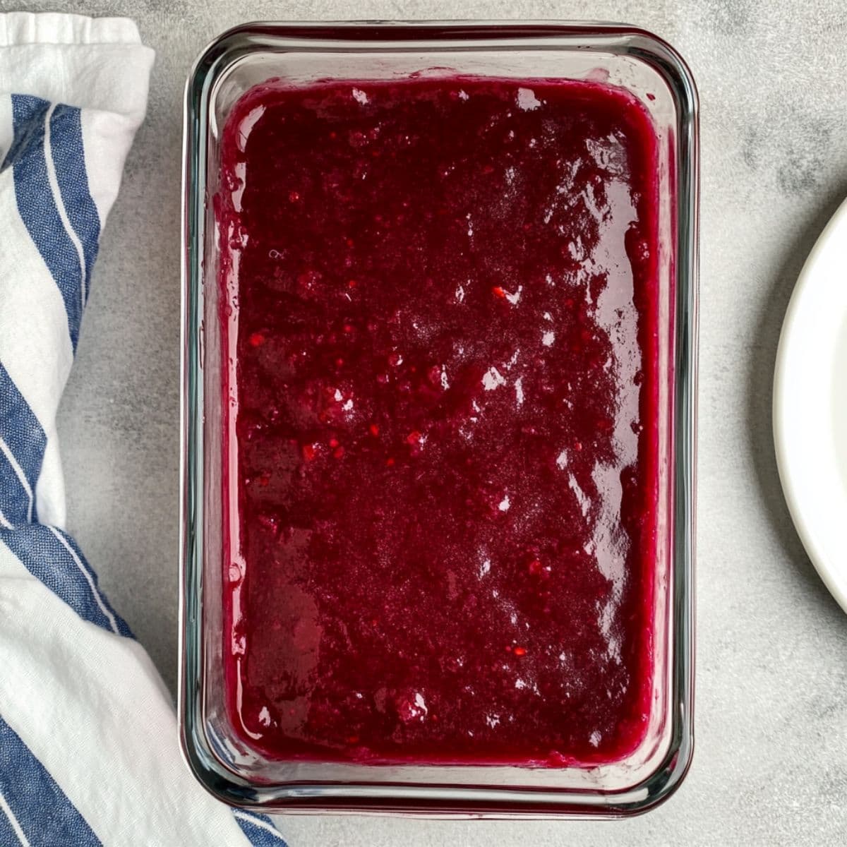 Dark berry mixture in a glass dish before freezing