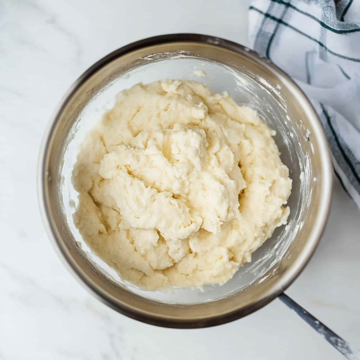 Soft Bisquick dumpling dough in a mixing bowl, ready to be spooned into chicken and dumplings.