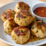 Chicken meatballs recipe showing golden-brown seared meatballs with fresh parsley garnish in cast iron skillet