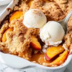 Sweet Summer Peach Cobbler That'll Make You Swoon Every Time 13 Peach cobbler recipe showing golden biscuit topping with fresh peaches and vanilla ice cream scoops in white baking dish