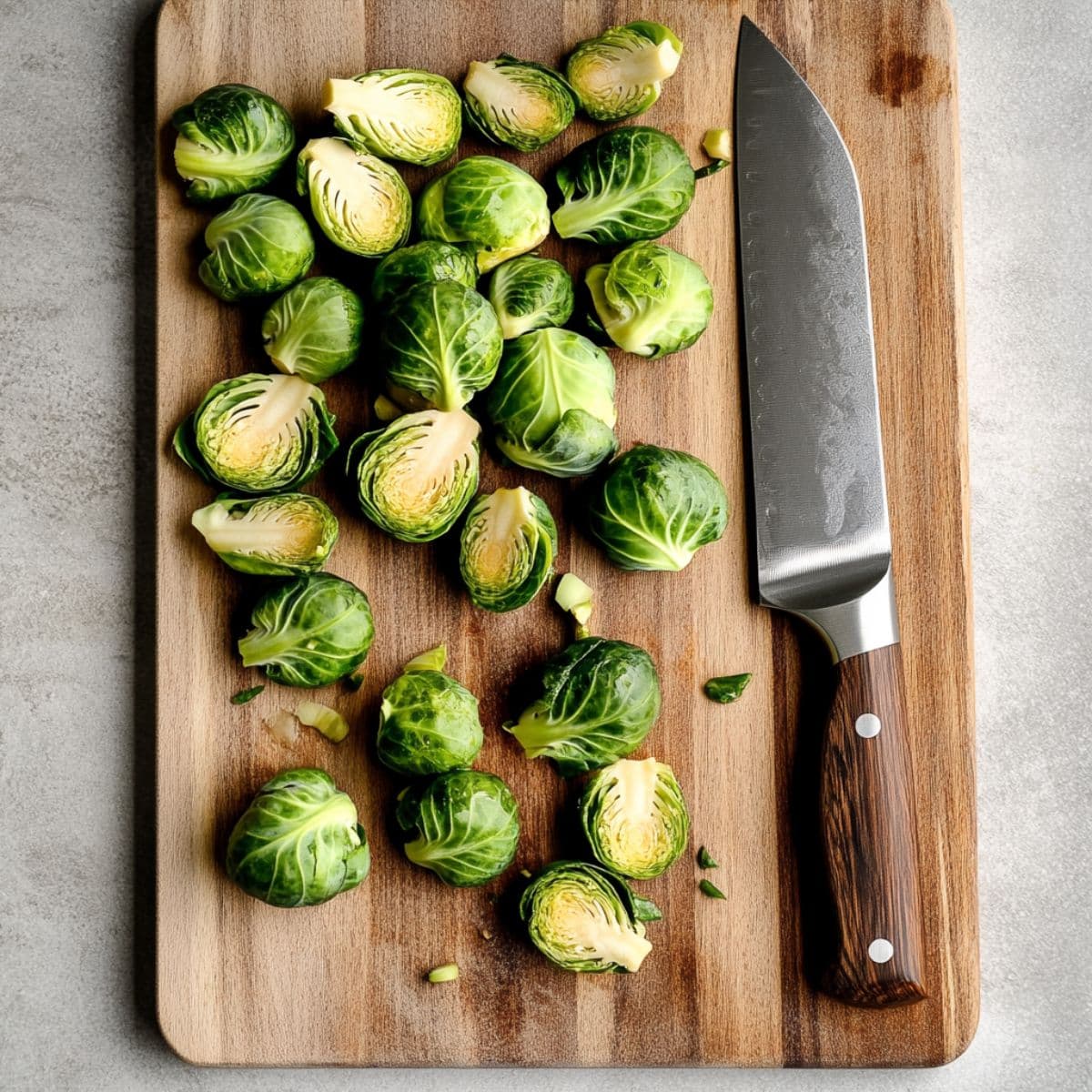 Fresh Brussels sprouts cut in half on wooden cutting board with knife, showing proper preparation technique for Longhorn steakhouse copycat recipe