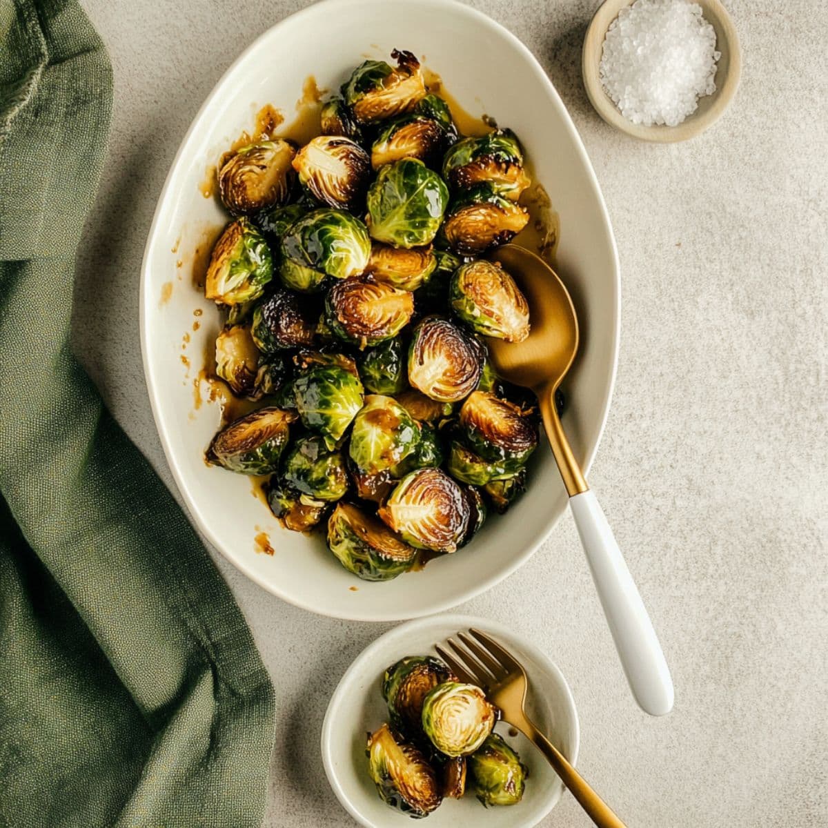 Perfect Longhorn Brussels sprouts served in elegant white bowls with gold utensils and sea salt, ready for steakhouse-style dining presentation