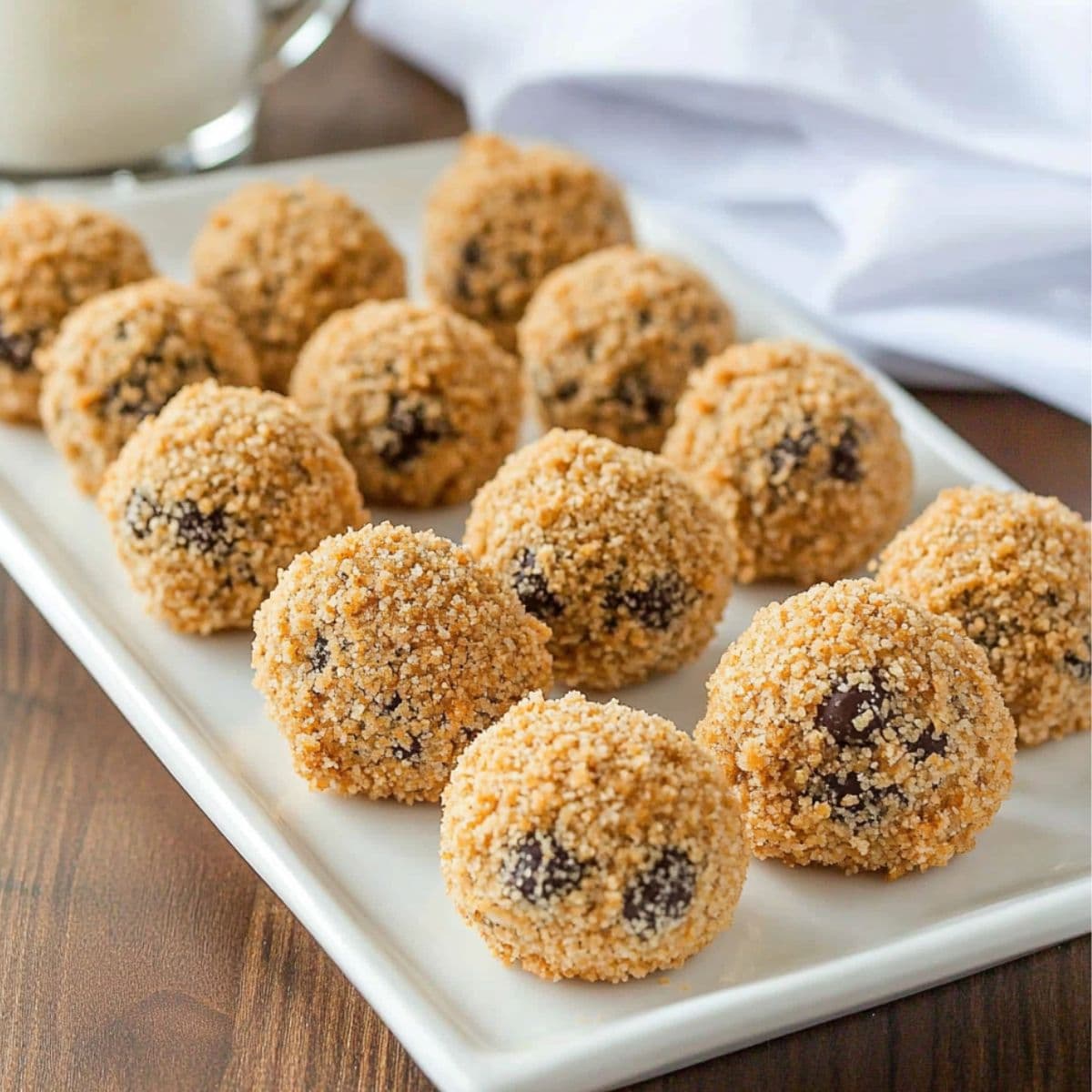 Moose farts recipe finished batch showing multiple golden coconut-coated no-bake treats with chocolate chips arranged on white serving platter