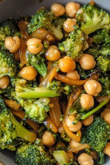 Perfect garlic broccoli stir fry with chickpeas showing crisp-tender broccoli florets, golden chickpeas and glossy sauce coating in close-up detail