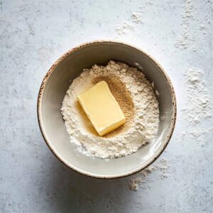 A bowl with flour, brown sugar, and butter ready to be mixed for a crumble base.