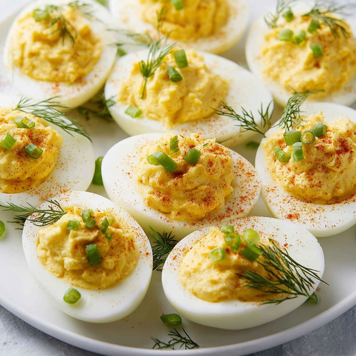 Deviled eggs with chives and dill garnish arranged on serving platter, perfect appetizer presentation for party entertaining