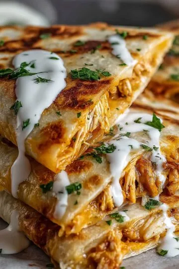Chicken quesadilla recipe showing golden crispy tortillas with melted cheese oozing out, topped with sour cream and fresh cilantro