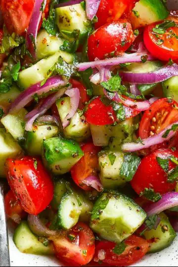 This cucumber and tomato salad recipe creates the most refreshing summer side dish with crisp vegetables, red onion, and tangy dressing. Ready in just 10 minutes using fresh farmers market produce for maximum flavor and crunch.