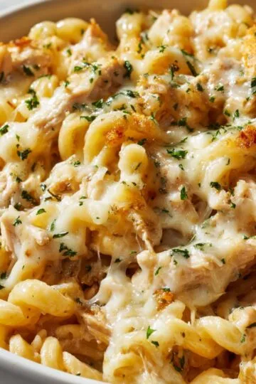 Mac and cheese recipe with golden bubbly top and fresh herbs in white baking dish showing perfect baked comfort food