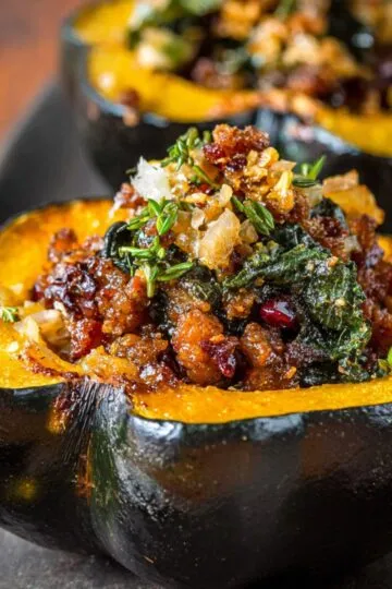 Acorn squash recipe stuffed with quinoa, kale, cranberries, and walnuts on wooden serving board