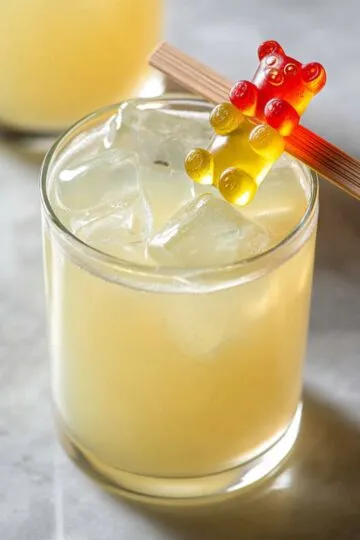 Gummy bear shot cocktail with colorful gummy bear garnish on rim showing sweet fruity vodka party drink