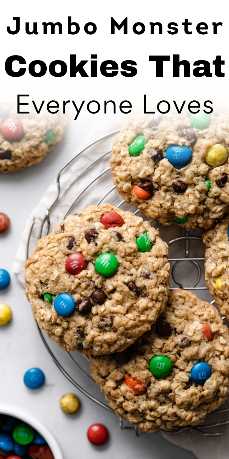 Jumbo monster cookies that everyone loves on wire rack showing thick oatmeal texture, M&Ms, chocolate chips with scattered candies around