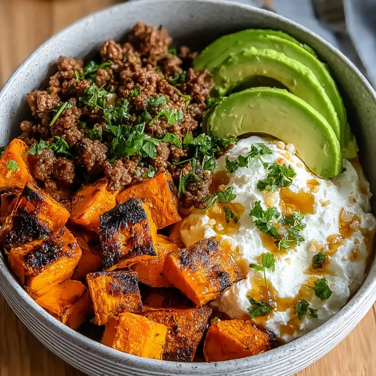 Ground beef hot honey bowl with roasted sweet potatoes, avocado, and yogurt.