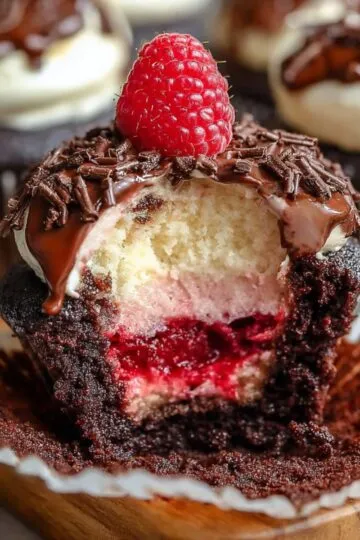 Cross-section of a chocolate cupcake showing raspberry filling and soft cream layers.
