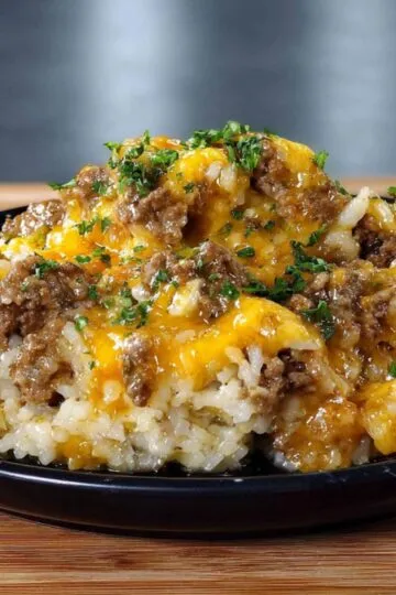 Garlic Butter Beef and Rice Skillet 9 Black plate filled with hot Garlic Butter Beef and Rice Skillet garnished with herbs.