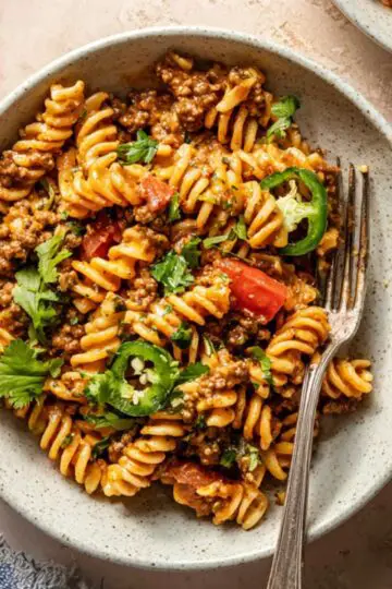 One Pot Taco Pasta 2 A warm bowl of One Pot Taco Pasta garnished with fresh cilantro and jalapeños.