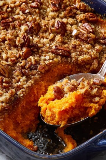 Blue baking dish filled with Ruth Chris sweet potato casserole and golden pecan crust.