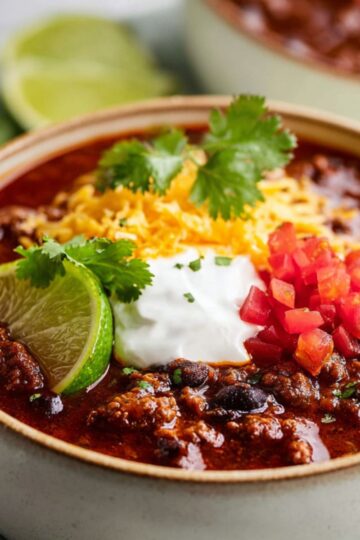 Savory vegan chili showing dark black beans and a crumbled meatless texture.