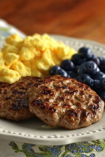 A plate filled with warm, golden brown breakfast turkey sausage patties ready to serve.